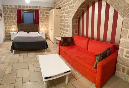 a living room with a bed and a red couch at Myral Guesthouse in Nafplio