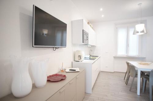 a kitchen with white cabinets and a tv on the wall at Cinque Terre Bridge in La Spezia