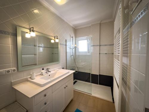 a bathroom with a sink and a shower and a mirror at Frontline Beach Villa Playa Flamenca in Orihuela