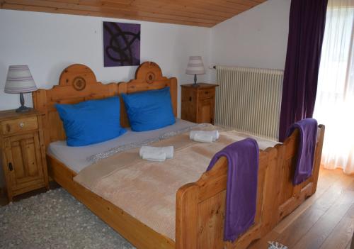 フラッハウにある4 Elements Appartmenthaus Monardaのベッドルーム1室(大型木製ベッド1台、青い枕付)