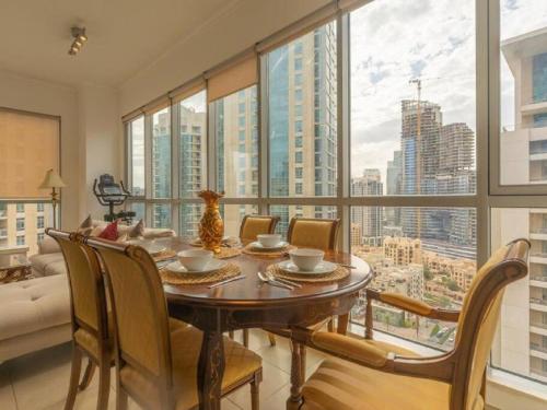 a dining room with a table and a large window at Elegant Apartment Overlooking Dubai Mall Fountain. in Dubai