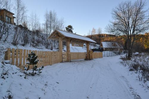 a wooden fence with a snow covered gate at Leśniówka Domki W Karpaczu in Karpacz
