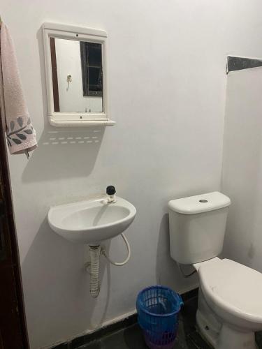 a white bathroom with a sink and a toilet at Pousada Recanto dos Leporage Itacuruçá in Mangaratiba