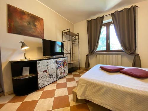 Un dormitorio con una cama y un televisor de pantalla plana. en Apartment Home Stadio, en Bussolengo