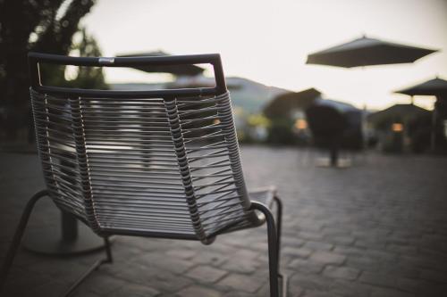 a metal bench sitting on a sidewalk with an umbrella at Weingut Gehlen-Cornelius in Brauneberg