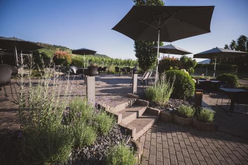 a patio with an umbrella and tables and chairs at Weingut Gehlen-Cornelius in Brauneberg