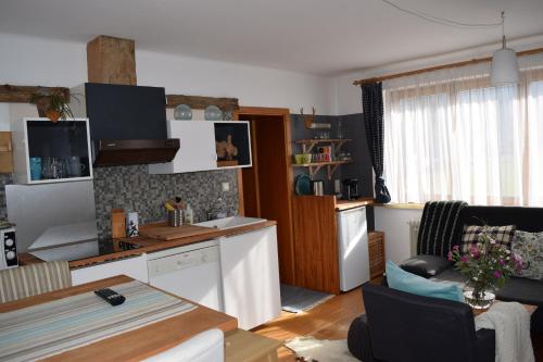 eine Küche und ein Wohnzimmer mit einem Tisch und einer Theke in der Unterkunft 4 Elements Appartmenthaus Monarda in Flachau