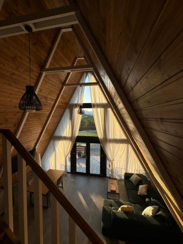 a living room with a couch in the attic at Mareva House A Frame Chalet in Râmnicu Vâlcea