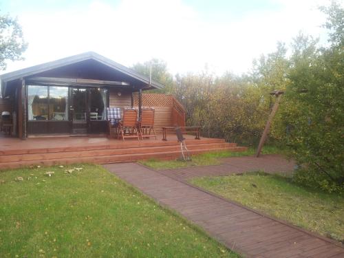 a log cabin with a porch and a patio at Vetursetur in Laxamýri