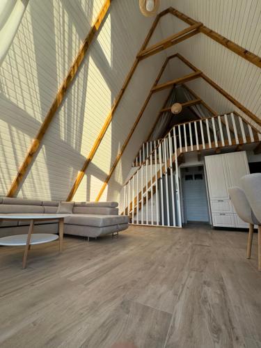 an attic room with a couch and a staircase at Mareva House A Frame Chalet in Râmnicu Vâlcea