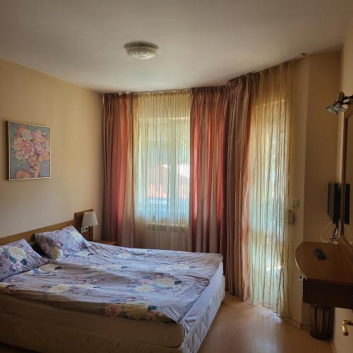 a bedroom with a bed and a window with curtains at Royal Plaza Apartments Borovets in Borovets