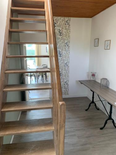 - un escalier en bois en colimaçon dans une chambre avec un bureau dans l'établissement Sur la route du Mont Saint Michel, à Isigny-le-Buat