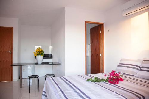 a bedroom with a bed with flowers on it at Mandacaru Flat in São Miguel do Gostoso