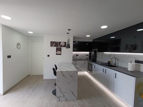 a kitchen with white cabinets and a marble counter top at Quinta do Araçal T1 in Horta