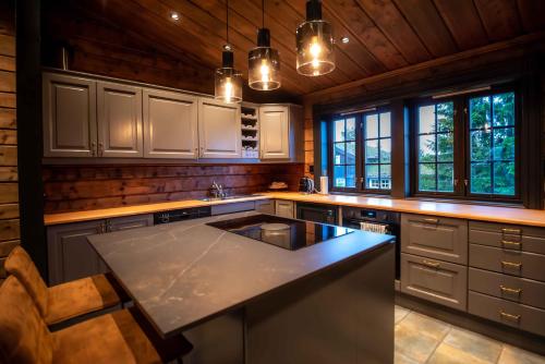 a kitchen with white cabinets and a black counter top at Trysilfjellet Nord 170 in Trysil