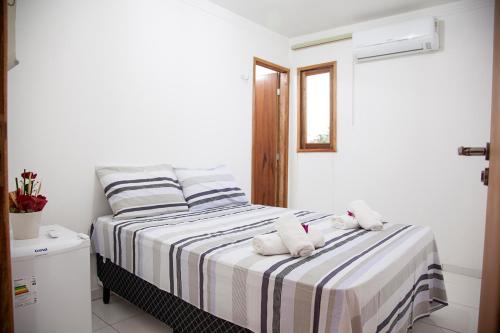 ein Schlafzimmer mit einem Bett mit zwei Handtüchern darauf in der Unterkunft Mandacaru Flat in São Miguel do Gostoso