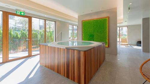 a large bathroom with a tub in a room with windows at VacationClub Apartamenty Zakopiańskie Apartament 250 in Zakopane