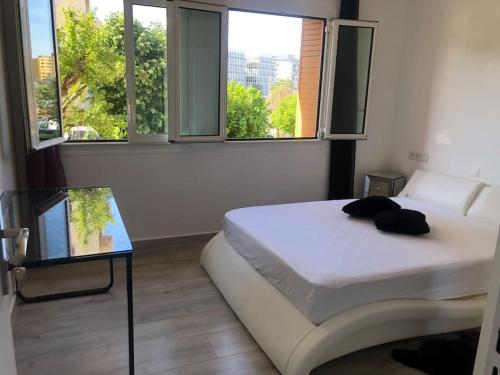 - une chambre avec un lit, une table en verre et des fenêtres dans l'établissement Design appartement, à Nice