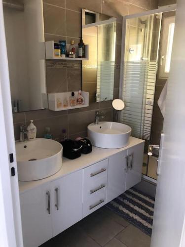 une salle de bain avec deux lavabos et un miroir dans l'établissement Design appartement, à Nice