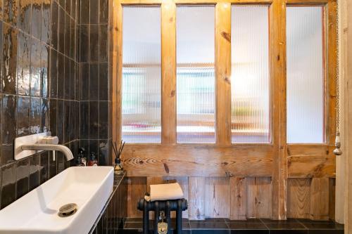 a bathroom with a sink and a window at Monarc House by Big Skies Cottages in Baconsthorpe