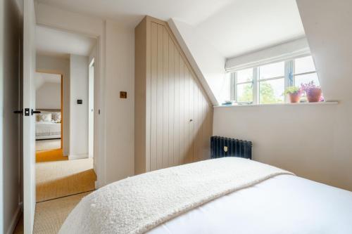 a bedroom with a white bed and a window at Monarc House by Big Skies Cottages in Baconsthorpe