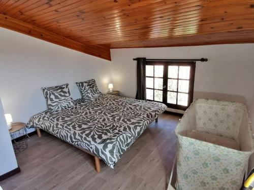 une chambre avec un lit, une chaise et une fenêtre dans l'établissement Le Murier en Ardèche, 10 personnes, avec sauna, à Saint-Marcel-dʼArdèche