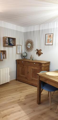 un salon avec une table et une armoire en bois dans l'établissement Bienvenue à l'Appart' !, à Lacanau