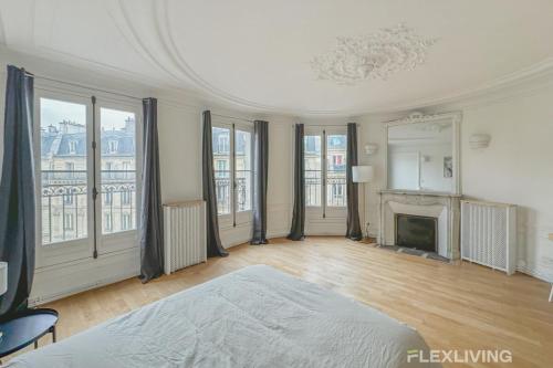 une grande pièce avec un lit et une cheminée dans l'établissement Flexliving - room - Turbigo, à Paris