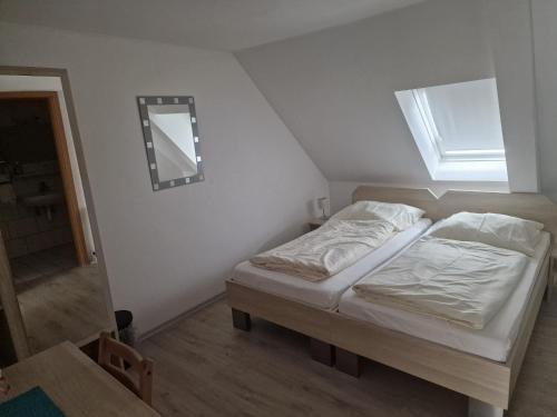a bedroom with a bed with a window and a mirror at Gasthof / Pension Götzfried in Tegernheim