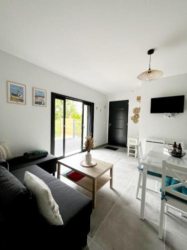 un salon avec un canapé et une table dans l'établissement Le Neptune, à Sainte-Mère-Église