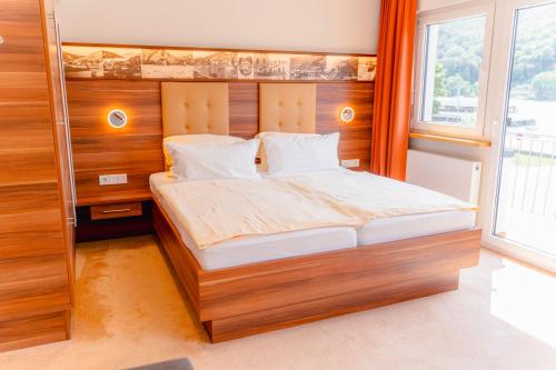 a bedroom with a large bed with wooden walls at Hotel Unter den Linden in Rüdesheim am Rhein