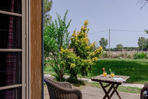 a table with drinks on it next to a yard at Le Mas Des Sables in Aigues-Mortes