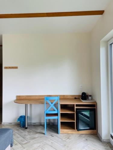a desk with a blue stool in a room at URychertow in Kiełpino
