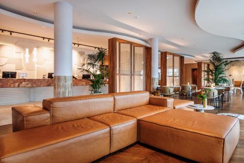 a living room with a brown leather couch at Van der Valk Hotel Eindhoven-Best in Best