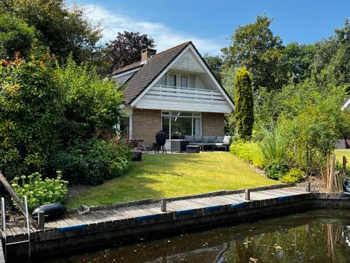 a house next to a body of water at Vakantiehuis Lytse Mar in Idskenhuizen