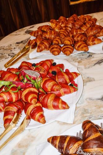 a table topped with plates of pastries and croissants at Van der Valk Hotel Eindhoven-Best in Best