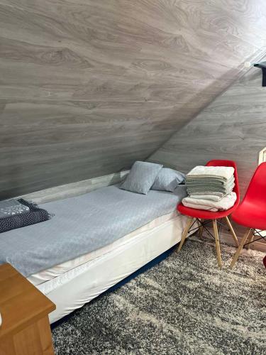 a bedroom with a bed and two red chairs at Не дорогой отель in Chişinău