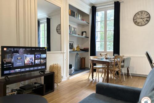 - un salon avec une télévision et une table à manger dans l'établissement Le Jeanne d'Arc - 4pers Pl du Vieux Marché, à Rouen