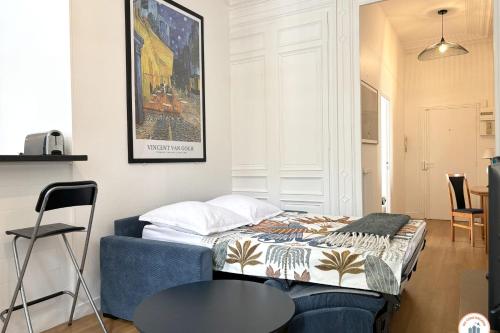 une chambre avec un lit et une table dans une pièce dans l'établissement Le Jeanne d'Arc - 4pers Pl du Vieux Marché, à Rouen