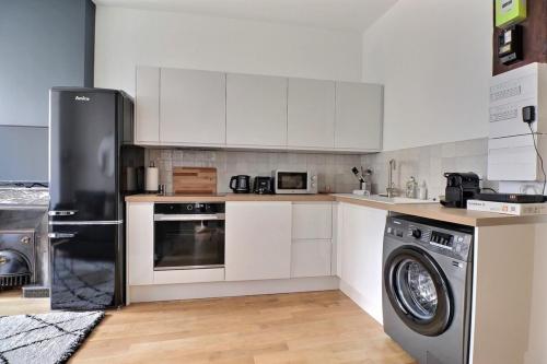 une cuisine avec des armoires blanches et une laveuse et une sécheuse dans l'établissement The Herriot - T3 in the Heart of the City - Lyon 1st, à Lyon