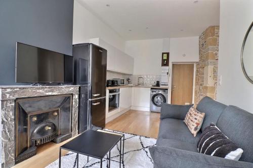 un salon avec un canapé bleu et une cheminée dans l'établissement The Herriot - T3 in the Heart of the City - Lyon 1st, à Lyon