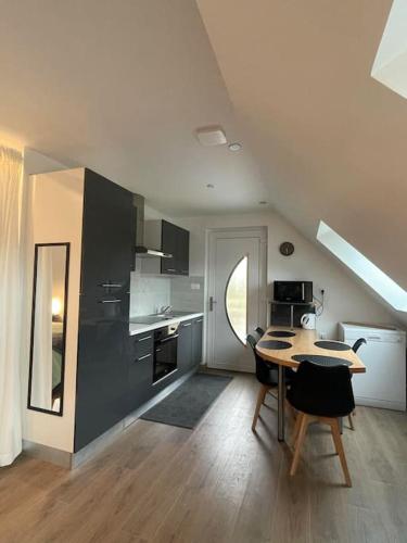 une cuisine avec une table et des chaises dans une pièce dans l'établissement breizh sweet home, à Treffendel