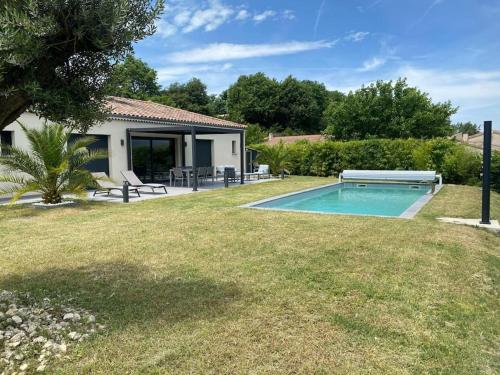a backyard with a swimming pool and a house at Magnifique villa avec piscine, Jacuzzi et Baignoire Balnéo in Upie