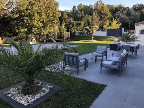 a patio with chairs and tables and a playground at Magnifique villa avec piscine, Jacuzzi et Baignoire Balnéo in Upie
