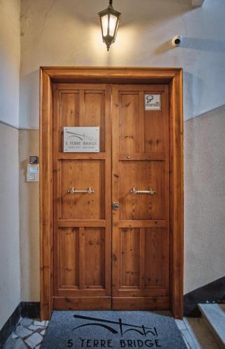 a large wooden door with a light on top at Cinque Terre Bridge in La Spezia