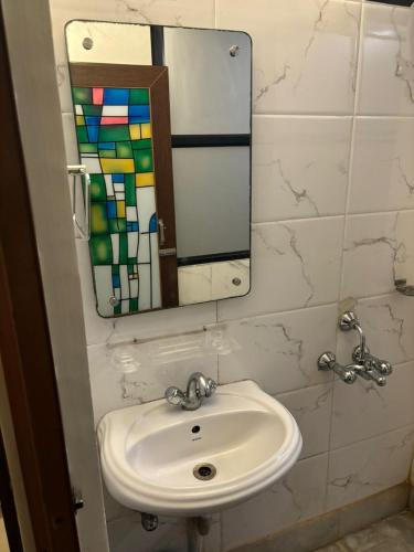 a bathroom with a sink and a mirror at Om Sai Villa Guesthouse in Kolkata