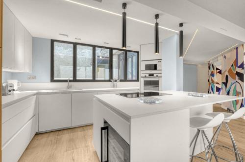 une cuisine avec des placards blancs et un comptoir blanc dans l'établissement L’échappée Capitulaire - Belle vue de Toulouse, à Toulouse