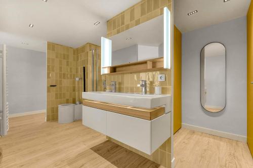 une salle de bain avec un lavabo blanc et un miroir dans l'établissement L’échappée Capitulaire - Belle vue de Toulouse, à Toulouse