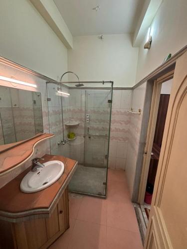 a bathroom with a sink and a glass shower at Om Sai Villa Guesthouse in Kolkata