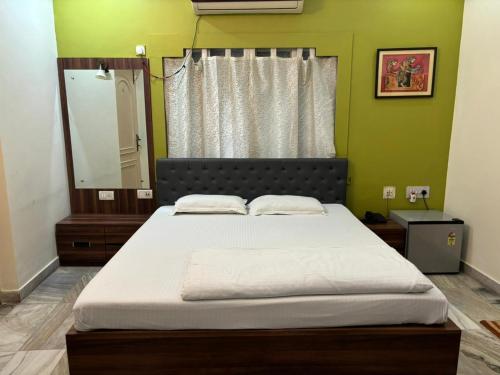 a bedroom with a large bed with a mirror at Om Sai Villa Guesthouse in Kolkata